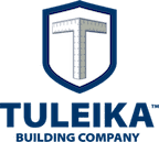 Logo of tuleika building company featuring a metallic square ruler forming the letter 't' on a shield background.